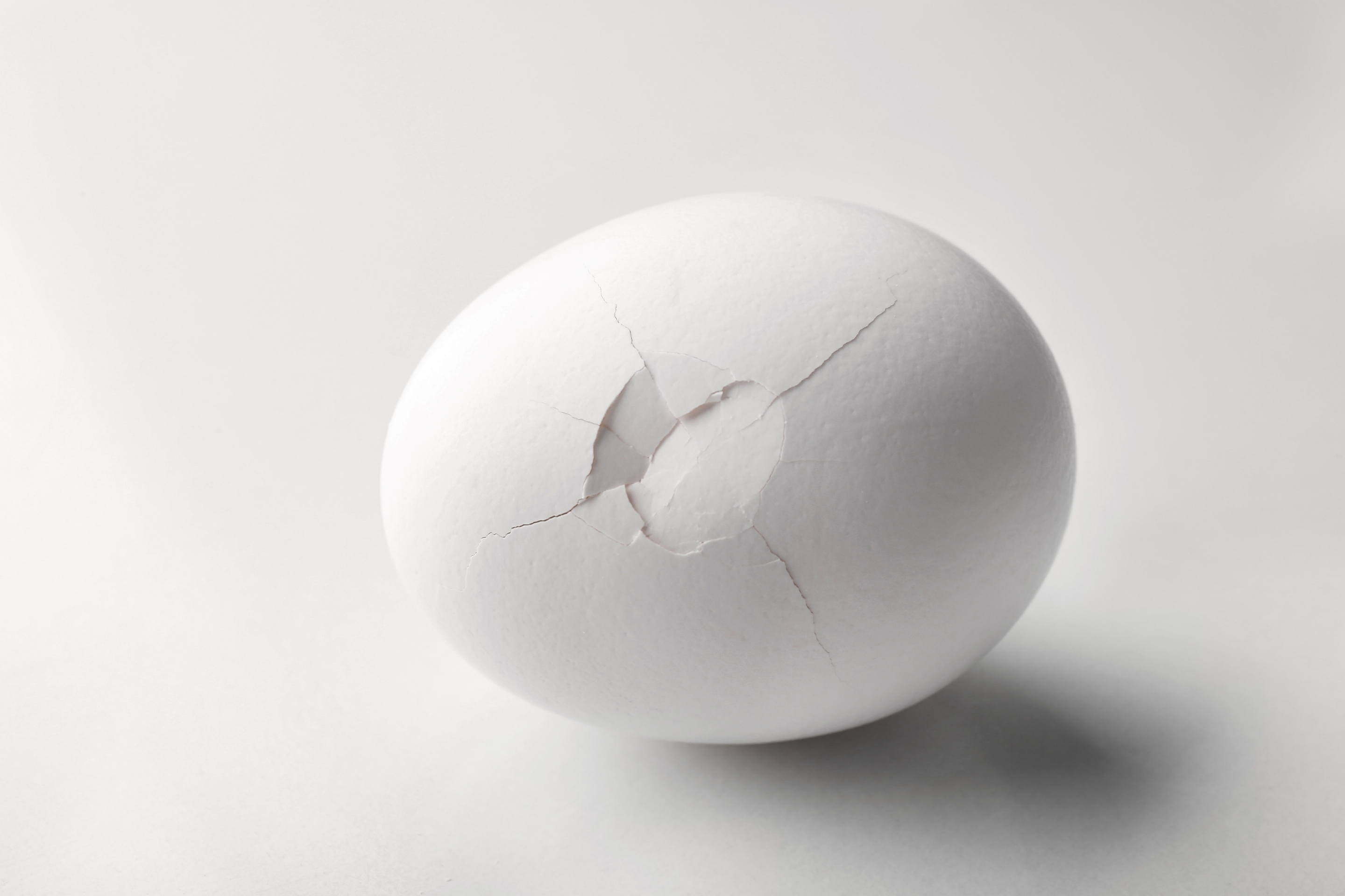 Яйцо трещина. Яйцо с трещиной. Белое яйцо с трещиной. Яйцо с трещиной на белом фоне. Стилизованная трещина на яйце.